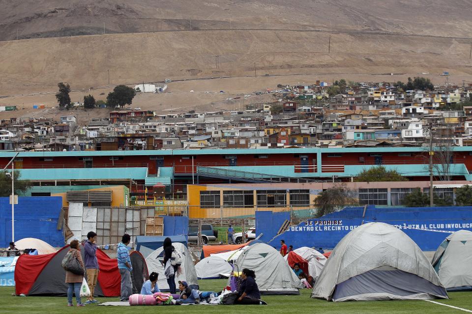 People camp out at a soccer field after a strong aftershock in Iquique, Chile, Friday, April 4, 2014. Coastal residents of Chile's far north have spent sleepless nights outside their homes as aftershocks continued following a magnitude-8.2 earthquake early in the week that damaged several thousand homes and caused six deaths. (AP Photo/Luis Hidalgo).