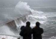 Waves crash over the breakwater of Saint Evette harbour at Esquibien in Brittany as an Atlantic storm hits western France, December 23, 2013. REUTERS/Mal Langsdon