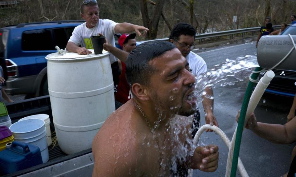 People affected by Hurricane Maria bathe in water piped in from a mountain creek, in Naranjito, Puerto Rico, amid concerns about islanders’ exposure to contaminated water.