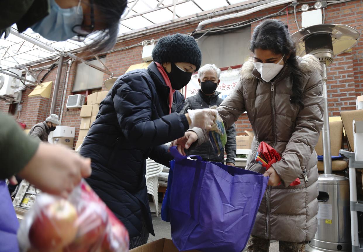 United Sherpa Association treasurer Tshering Sherpa, center, helps college students Jyoti Rajbanshi of Long Island University, left, and Lalsa Pandit of Laguardia Community College, right, pack free food in bags during the group's weekly food pantry in January in Queens.