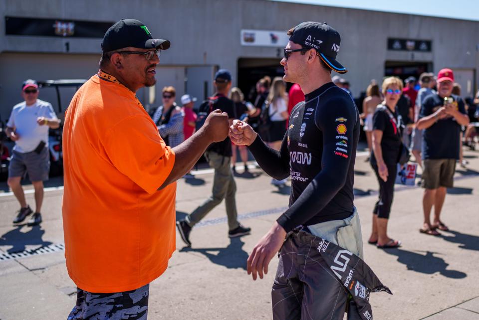 Arrow McLaren SP driver Pato O'Ward (5) fist bumps a fan in the garage area Sunday, May 21, 2023, prior to second day of qualifying practice at Indianapolis Motor Speedway in preparation for the 107th running of the Indianapolis 500.
