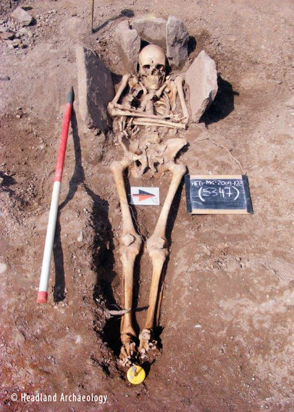 The skeleton of the medieval man, a possible knight, in his stone grave.