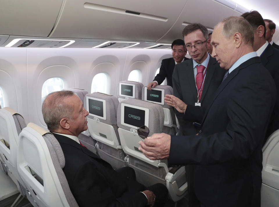 Turkey's President Recep Tayyip Erdogan, left, listens to Russia's President Vladimir Putin, as they inspect an aircraft during the MAKS-2019 International Aviation and Space Show in Zhukovsky, outside Moscow, Russia, Tuesday, Aug. 27, 2019. Erdogan is on a short working visit in Russia.(Presidential Press Service via AP, Pool)