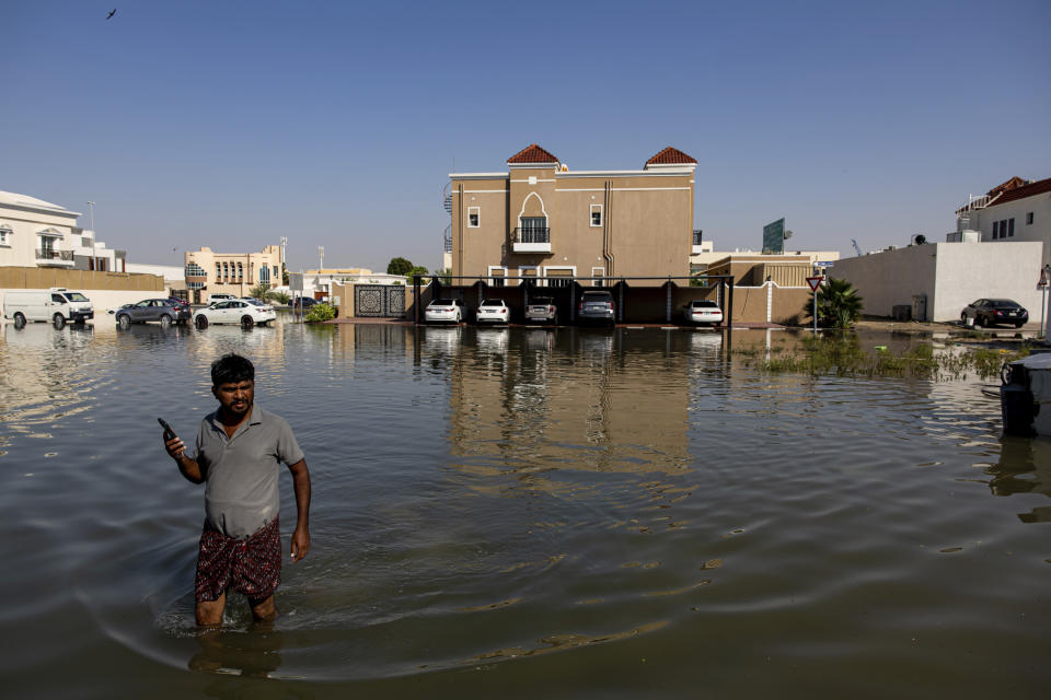 A man walks through standing floodwater caused by heavy rain in Dubai, United Arab Emirates, Thursday, April 18, 2024. The United Arab Emirates attempted to dry out Thursday from the heaviest rain the desert nation has ever recorded, a deluge that flooded out Dubai International Airport and disrupted flights through the world's busiest airfield for international travel. (AP Photo/Christopher Pike)