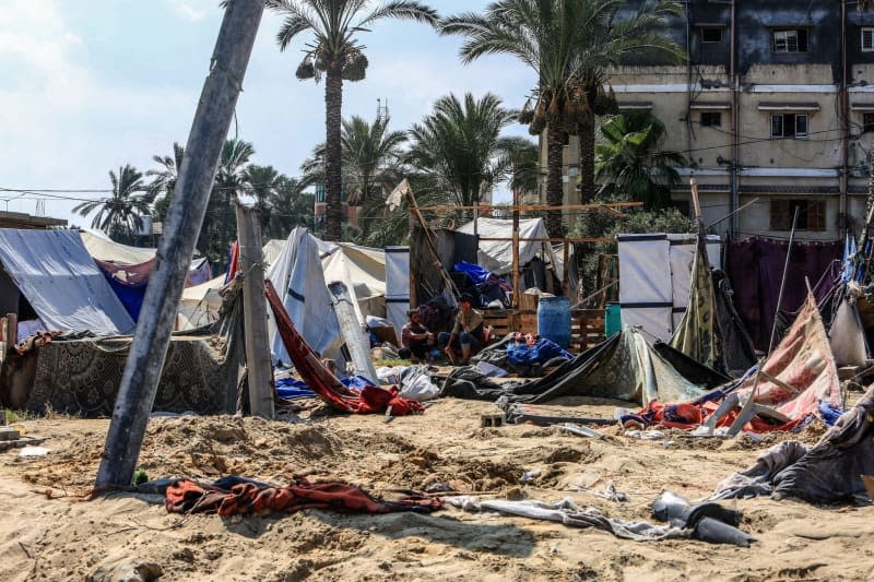 Displaced Palestinians return to their destroyed tents to inspect their belongings at the site of the Israeli bombing of Al-Mawasi camp the previous day, amid the ongoing conflict between Israel and Hamas.  Abed Rahim Khatib/dpa