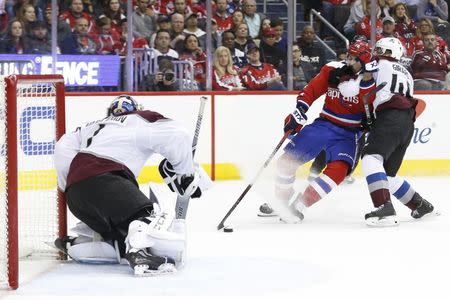 Feb 7, 2019; Washington, DC, USA; Washington Capitals center Chandler Stephenson (18) attempts to shoot the puck on Colorado Avalanche goaltender Semyon Varlamov (1) as Avalanche defenseman Samuel Girard (49) defends in the third period at Capital One Arena. The Capitals won 4-3 in overtime. Mandatory Credit: Geoff Burke-USA TODAY Sports