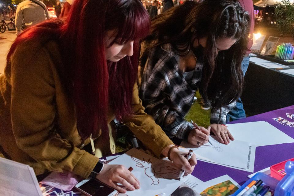 Anisa West and Jasmine West create designs for a mural with Sky’s the Limit Foundation at First Friday on Dec. 3, 2021, in Phoenix.