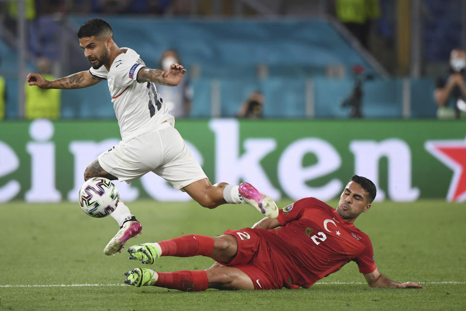 Italy's Lorenzo Insigne, left, is challenged by Turkey's Zeki Celik during the Euro 2020 soccer championship group A match between Italy and Turkey at the Olympic stadium in Rome, Friday, June 11, 2021. (Alberto Lingria/Pool Photo via AP)