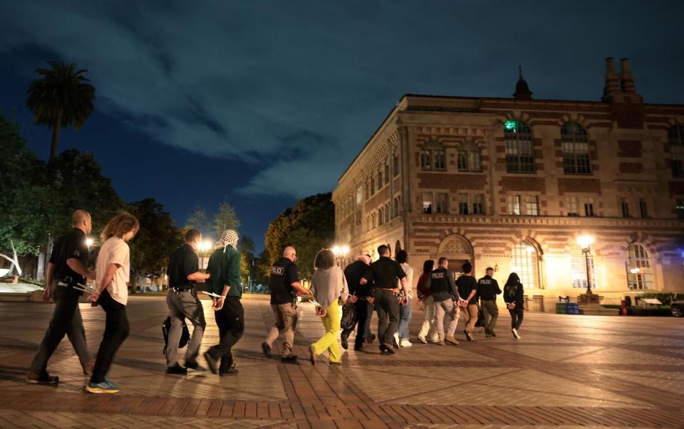 Protestors are detained by LAPD officers as tried to clear the USC campus.