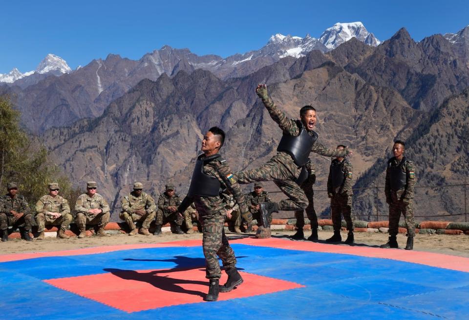 U.S. Army soldiers of the 2nd Brigade of the 11th Airborne Division watch Indian army soldiers display their unarmed combat skills during the Indo-U.S. joint exercise or "Yudh Abhyas, in Auli, in the Indian state of Uttarakhand, Tuesday, Nov. 29, 2022. Militaries from India and the U.S. are taking part in a high-altitude training exercise in a cold, mountainous terrain close to India's disputed border with China. The training exercise began two weeks ago. India's defence ministry statement said the joint exercise is conducted annually with the aim of exchanging best practices, tactics, techniques and procedures between the armies of the two nations, which is under Chapter of the UN Mandate. (AP Photo/Manish Swarup)