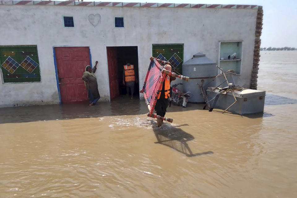 In this photo released by Rescue 1122 Emergency Department, rescue workers help villagers to evacuate them from a flooded area of Bahawalnagar district of Pakistan's Punjab province, Wednesday, Aug. 23, 2023. Rescuers have evacuated more than 100,000 people from flood-hit areas of Pakistan's eastern Punjab province in the past three weeks, officials said Wednesday. (Rescue 1122 Emergency Department vis AP)