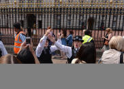 Police officers encourage members of the public, who are queuing to look at the official announcement that the Duke and Duchess of Cambridge have had a baby boy, to keep moving along, outside Buckingham Palace in London.