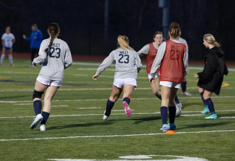 Members of the Althoff Catholic High School soccer team wear the jersey of Gabby Orlet while warming up before a match at Althoff High School in Belleville, Ill. on March 11, 2024.