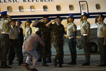 Angelos Mitretodis and Dimitris Kouklatzis, two Greek soldiers who were detained in Turkey after crossing the border, salute a guard of honor after being released, at the airport of Thessaloniki, Greece, August 15, 2018. REUTERS/Alexandros Avramidis