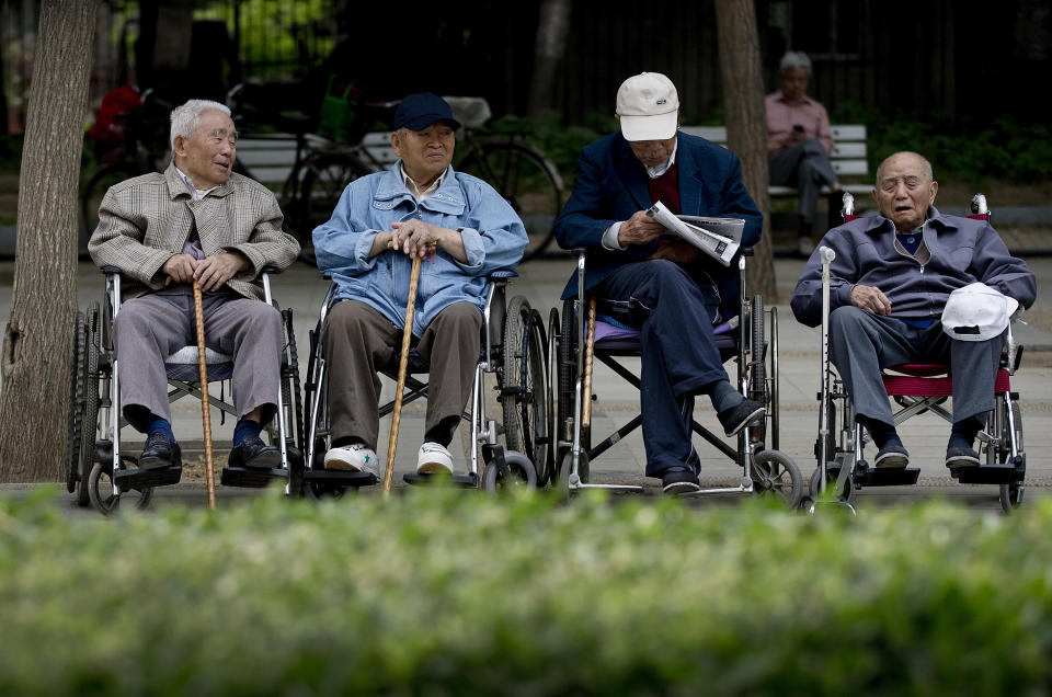 In this Thursday, May 23, 2013 photo, a group of elderly men take a rest on their wheelchairs at a park in Beijing. New wording in the law requiring people to visit or keep in touch with their elderly parents or risk being sued came into force Monday, July 1, 2013, as China faces increasing difficulty in caring for its aging population. (AP Photo/Andy Wong)