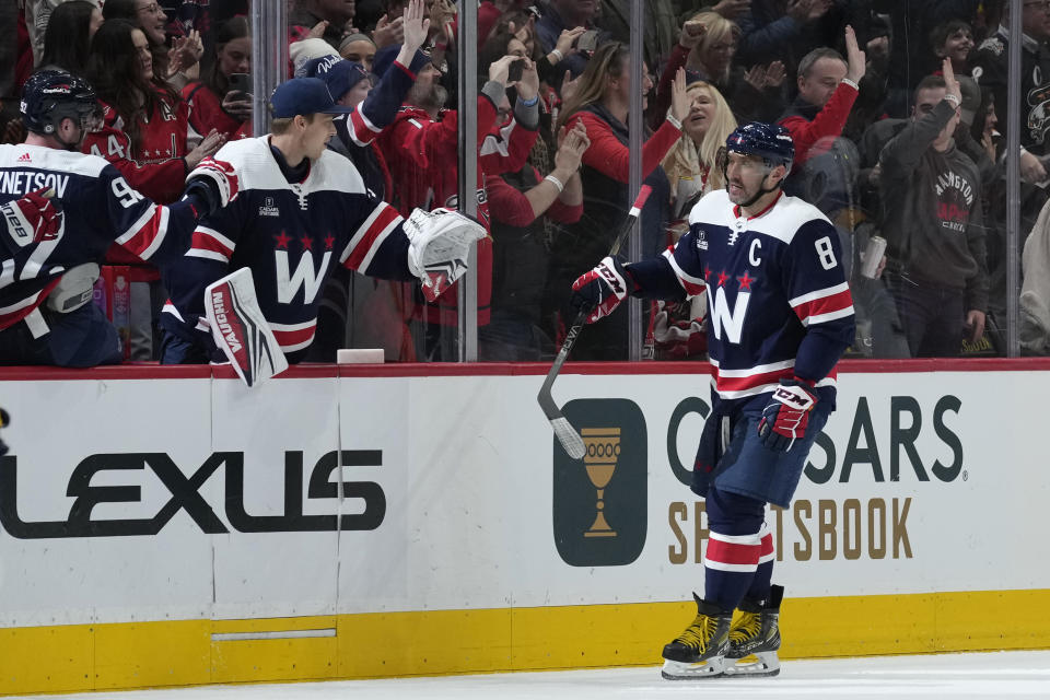 Washington Capitals left wing Alex Ovechkin (8) is congratulated after scoring during the second period of an NHL hockey game against the Nashville Predators in Washington, Saturday, Dec. 30, 2023. (AP Photo/Susan Walsh)