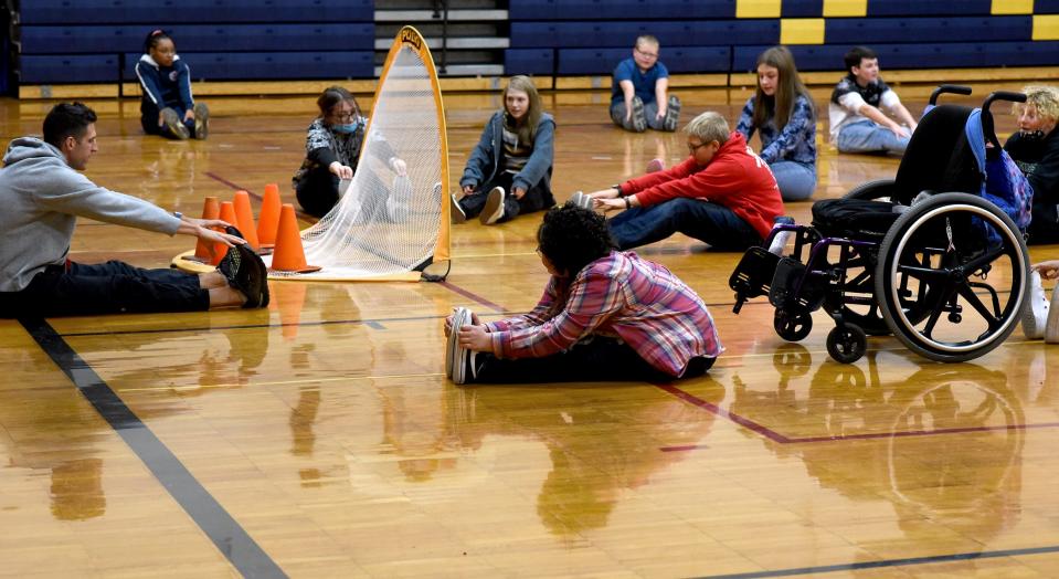 Elly Wickenheiser, 13, of Carleton stretches out with her eighth grade classmates at Wagar Middle School as gym teacher Ryan Marino leads the class.