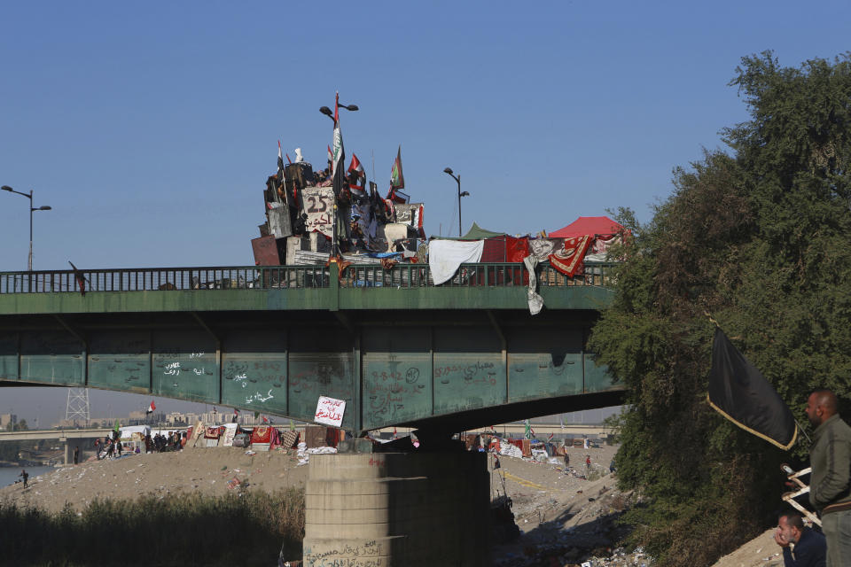 Anti-government protesters stage a sit-in on a bridge leading to the Green Zone government areas, during ongoing protests in Baghdad, Iraq, Thursday, Nov. 21, 2019. Iraqi officials say three anti-government protesters have been killed in clashes with security forces overnight in Baghdad. (AP Photo/Khalid Mohammed)