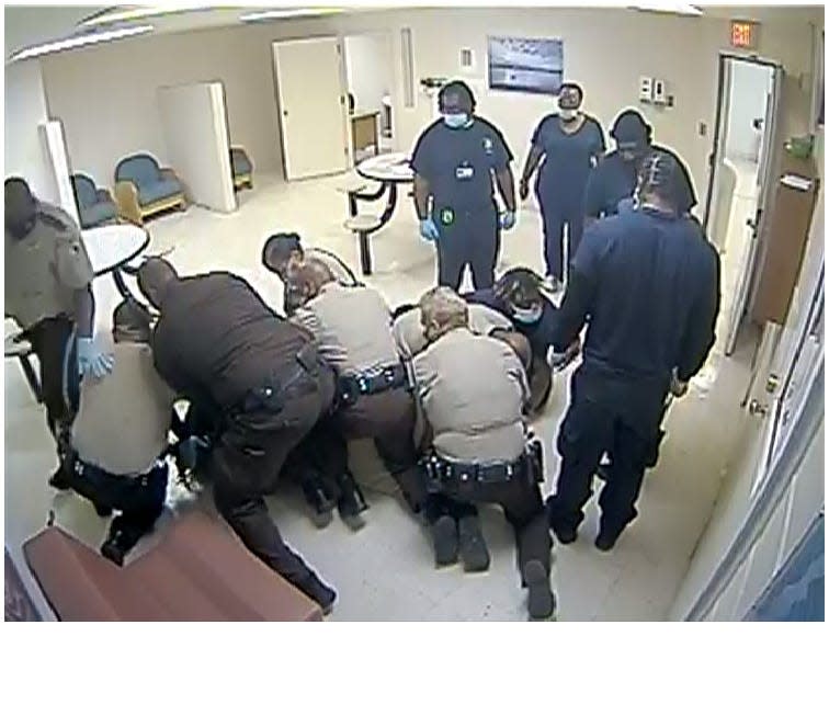 This image shows Henrico County deputies and Central State Hospital personnel restraining Irvo Otieno in the hospital's admissions area Monday, March 6, 2023, in Dinwiddie County. All seven deputies and one of the three security guards will stand trial for second-degree murder beginning this June.