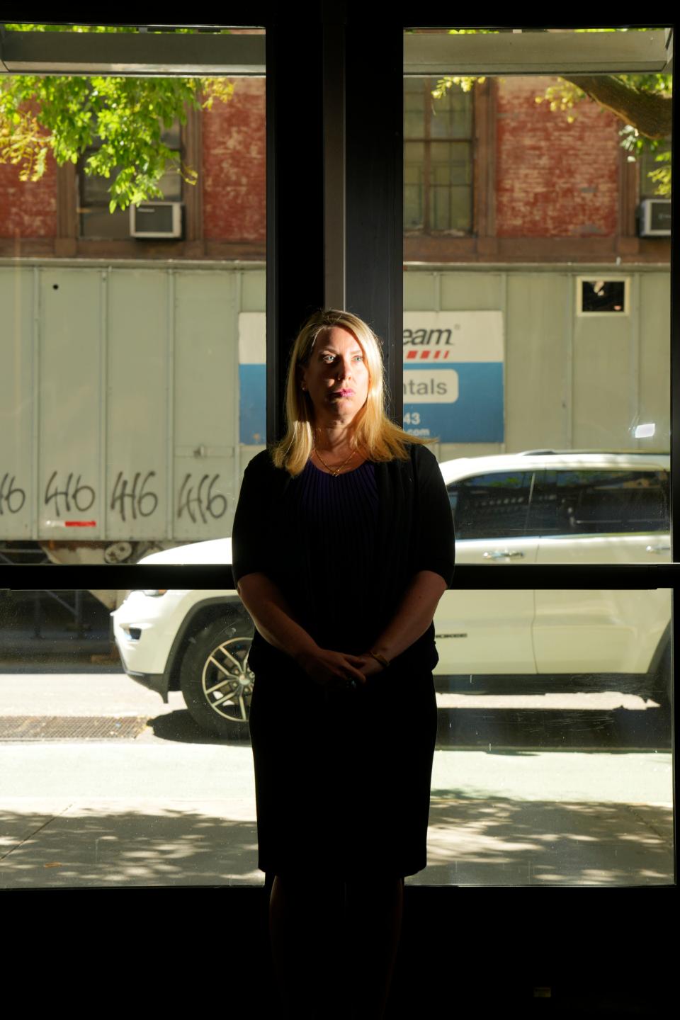 Rabbi Diane Fersko stands in front of the glass doors of the Village Temple in Manhattan. The doors were replaced after a bat was used on the previous set in 2020, in what is believed to be an act of antisemitism. "It's a shape-shifting type of hate. It's a clever, mutating virus that can affect anyone," she said.