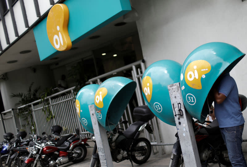 FILE PHOTO: A man talks on a payphone with the logo of Brazilian telecoms company Oi SA outside the company's office in Rio de Janeiro, Brazil December 22, 2017. REUTERS/Ricardo Moraes