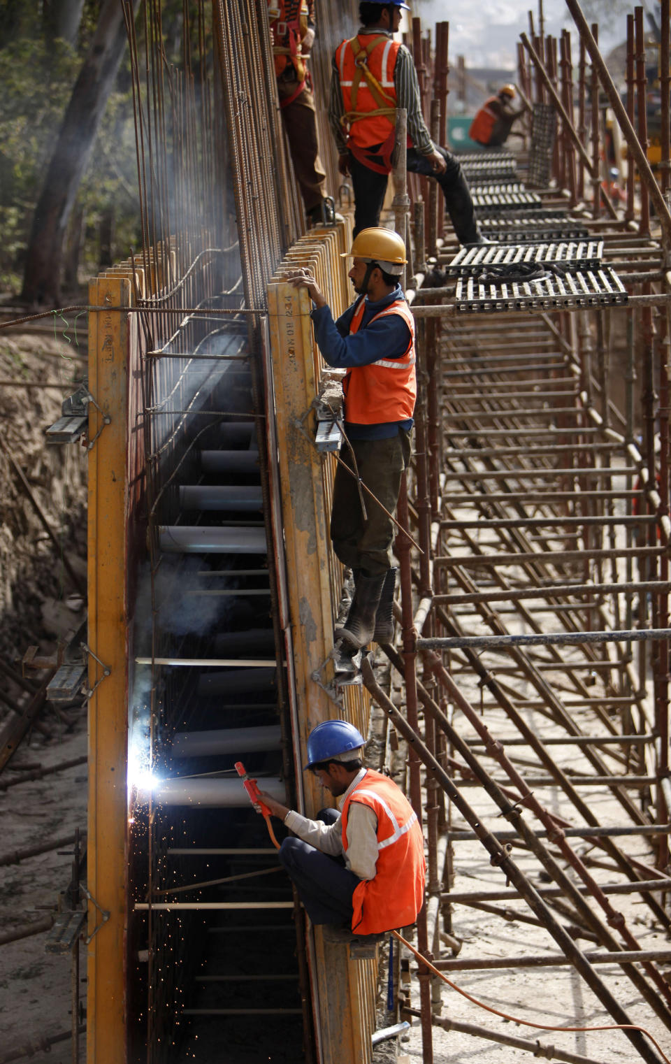 Indian laborers work at a construction site to build a bridge on the River Tawi in Jammu, India, Friday, March 16, 2012. Indian Finance Minister Pranab Mukherjee presented India's new budget Friday amid concerns about inflation, the country's falling growth rate and its large deficit. (AP Photo/Channi Anand)