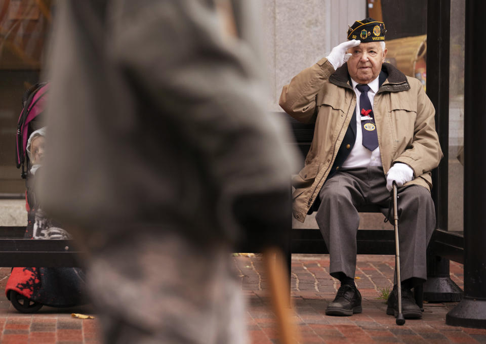 PORTLAND, ME - NOVEMBER 11: Tom Caron of Portland salutes soldiers walking along Congress Street during Portlands Veterans Day parade on Monday, November 11, 2019. Caron served in the U.S. Army in the 1950s and said he has participated in Portlands Veterans Day parade in the past but was showing his support for marchers this year from a covered a bus stop bench on Monday. (Staff Photo by Gregory Rec/Portland Press Herald via Getty Images)