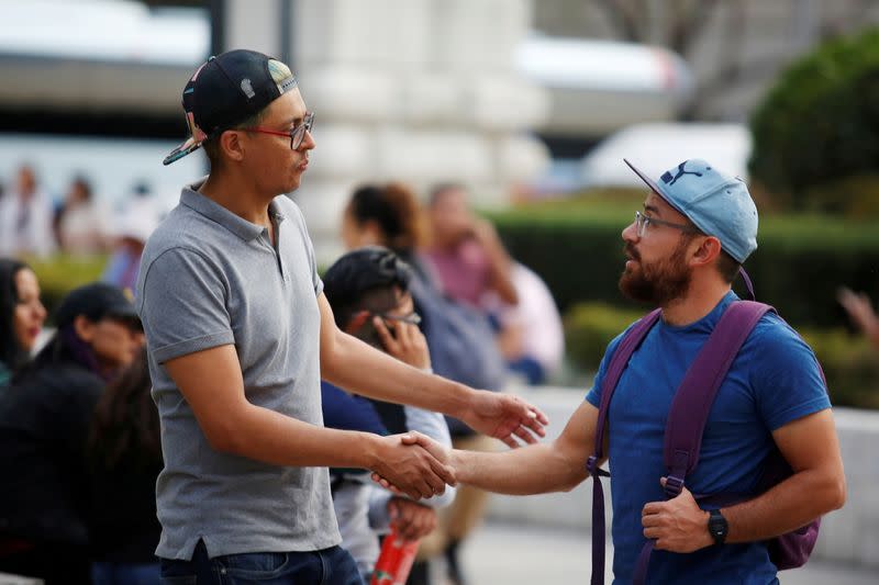 FILE PHOTO: Men shake hands outside the Palacio de Bellas Artes in Mexico City