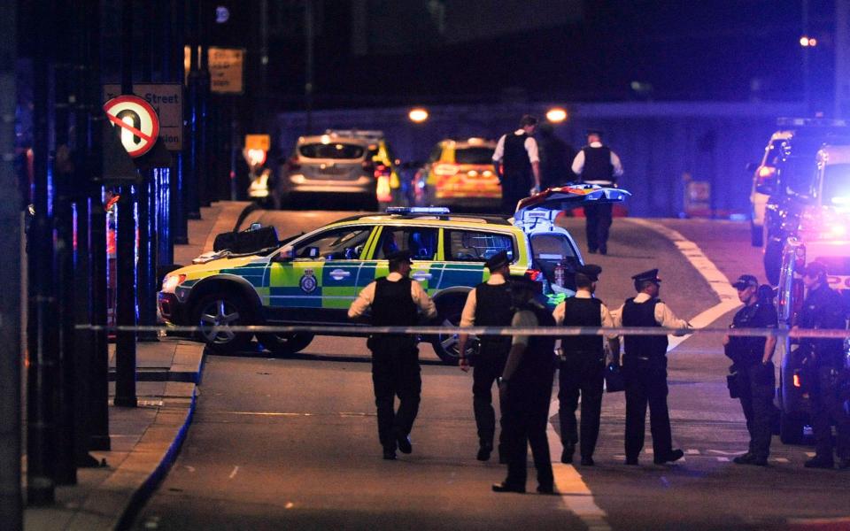 Police officers walk at the scene of an apparent terror attack on London Bridge - Credit: AFP