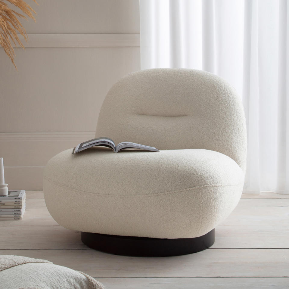 White boucle chair in a white room with white sheer curtains