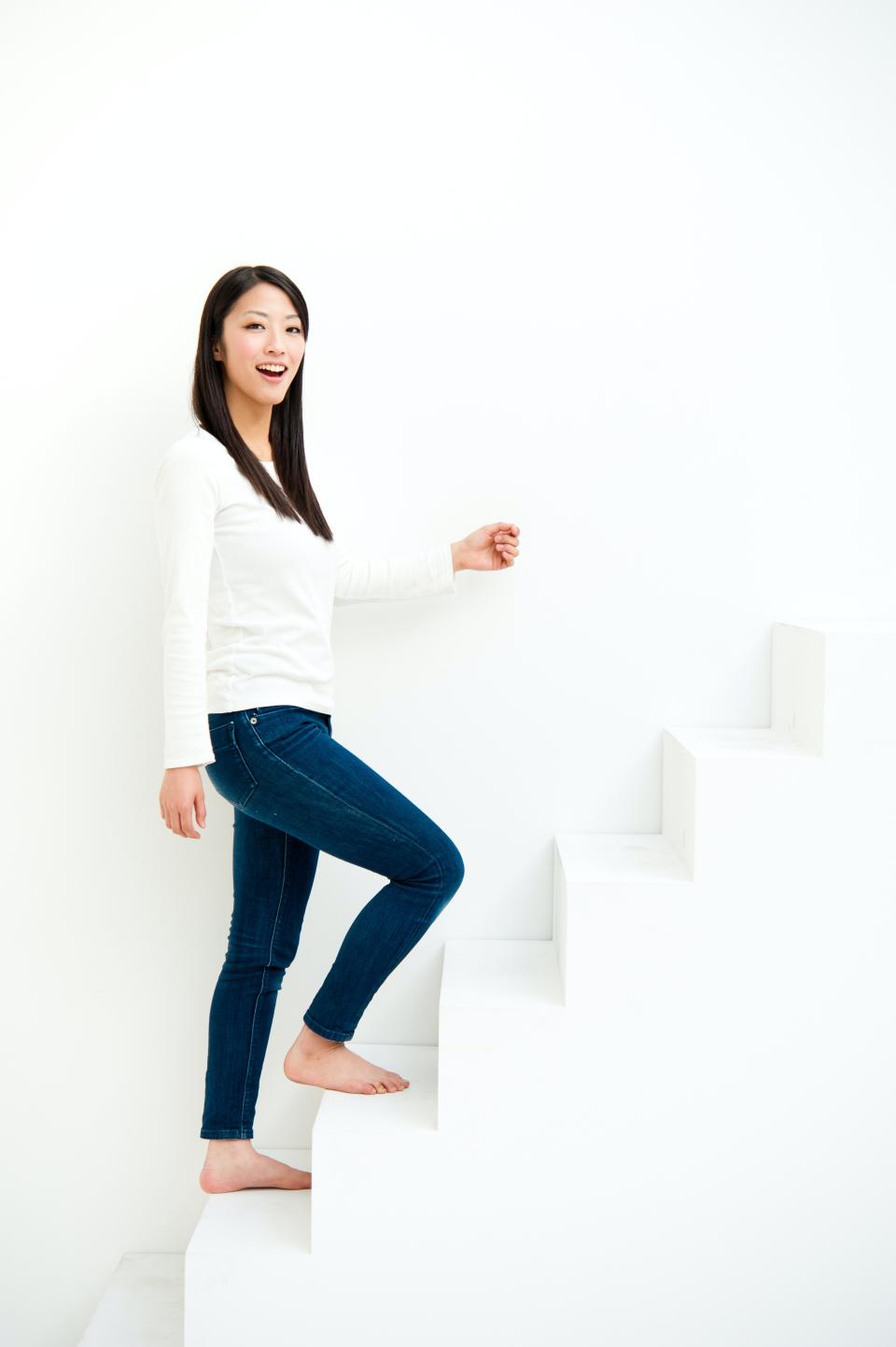 Une femme qui monte un escalier blanc