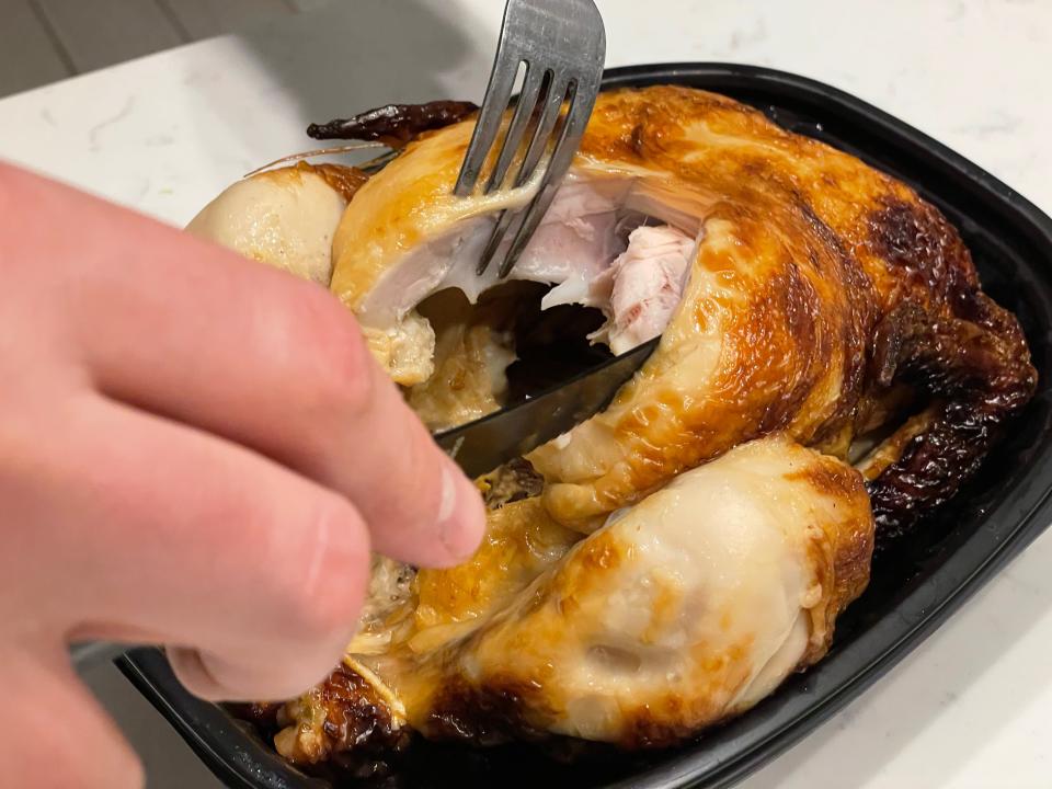 The writer cuts into the breast meat of Meijer rotisserie chicken