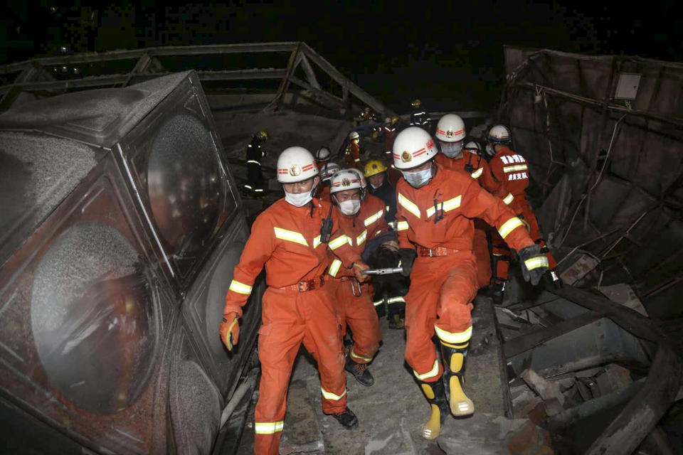 Rescuers carry an injured man (C) out of the rubble of a collapsed hotel in Quanzhou, in China's eastern Fujian province on March 7, 2020. - Around 70 people were trapped after the Xinjia Hotel collapsed on March 7 evening, officials said. (Photo by STR / AFP) / China OUT (Photo by STR/AFP via Getty Images)