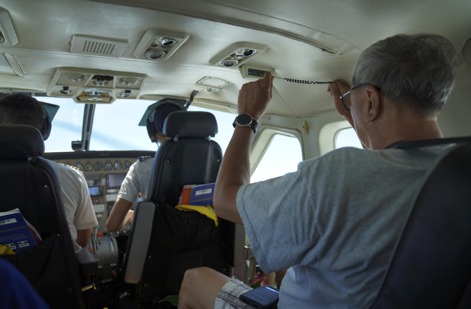 Lance Toyofuku prays with rosary beads while on an eight-seat plane from Honolulu to the peninsula of Kalaupapa, Hawaii, on Tuesday, July 18, 2023. In the 1800s, Kalaupapa was a settlement for banished leprosy patients, later called Hansen's disease. It's now a refuge for the eight former patients who still call the peninsula home. (AP Photo/Jessie Wardarski)