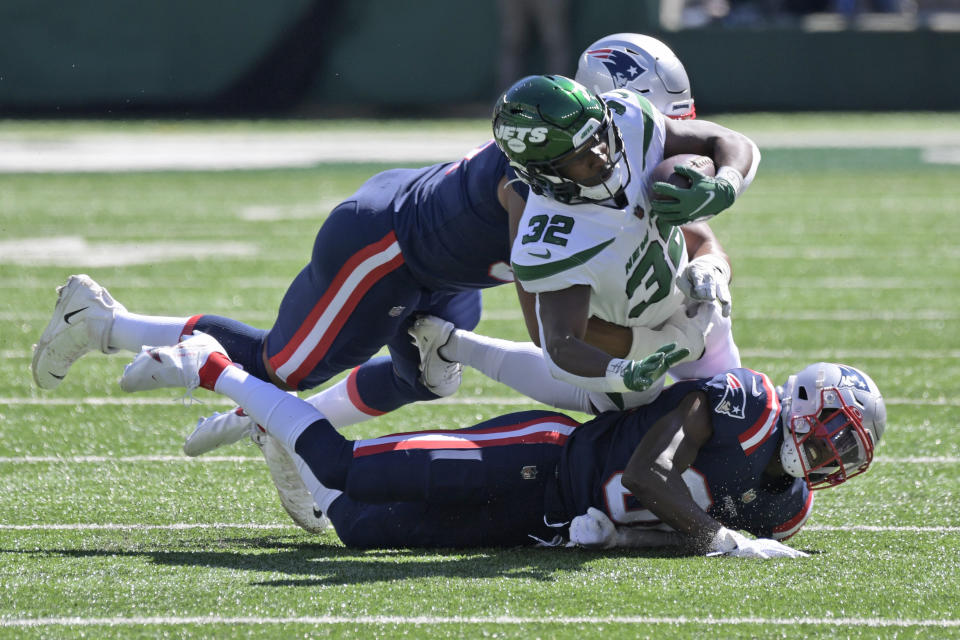 New York Jets running back Michael Carter, center, is brought down by New England Patriots defenders during the first half of an NFL football game, Sunday, Sept. 19, 2021, in East Rutherford, N.J. (AP Photo/Bill Kostroun)