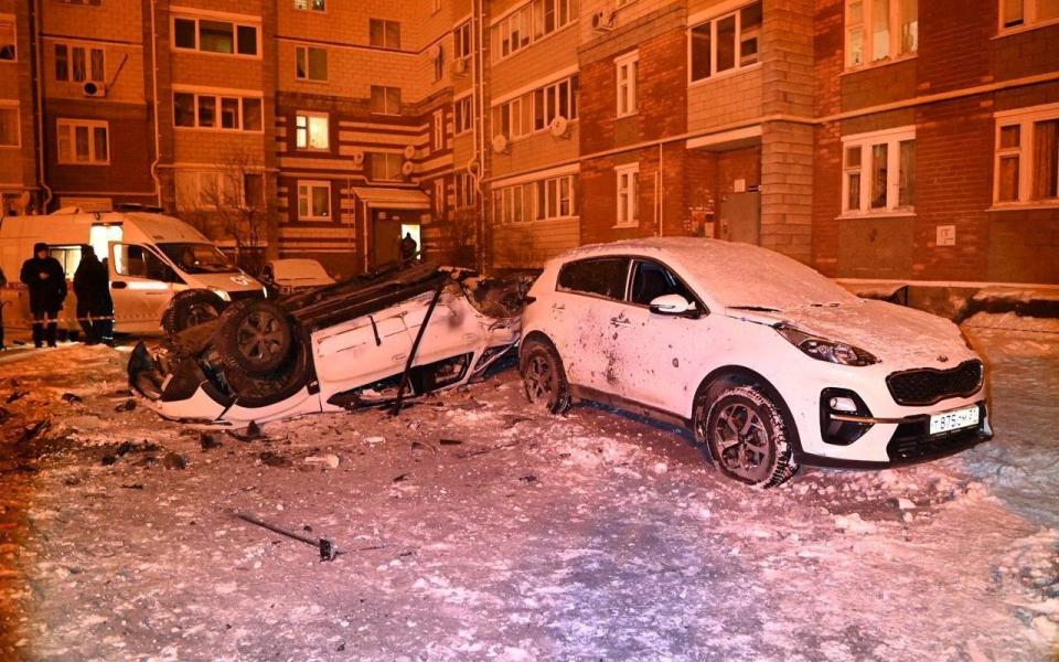 A view shows damaged cars in a courtyard of a multi-story apartment building following what local authorities say was a Ukrainian military strike in the city of Belgorod, Russia