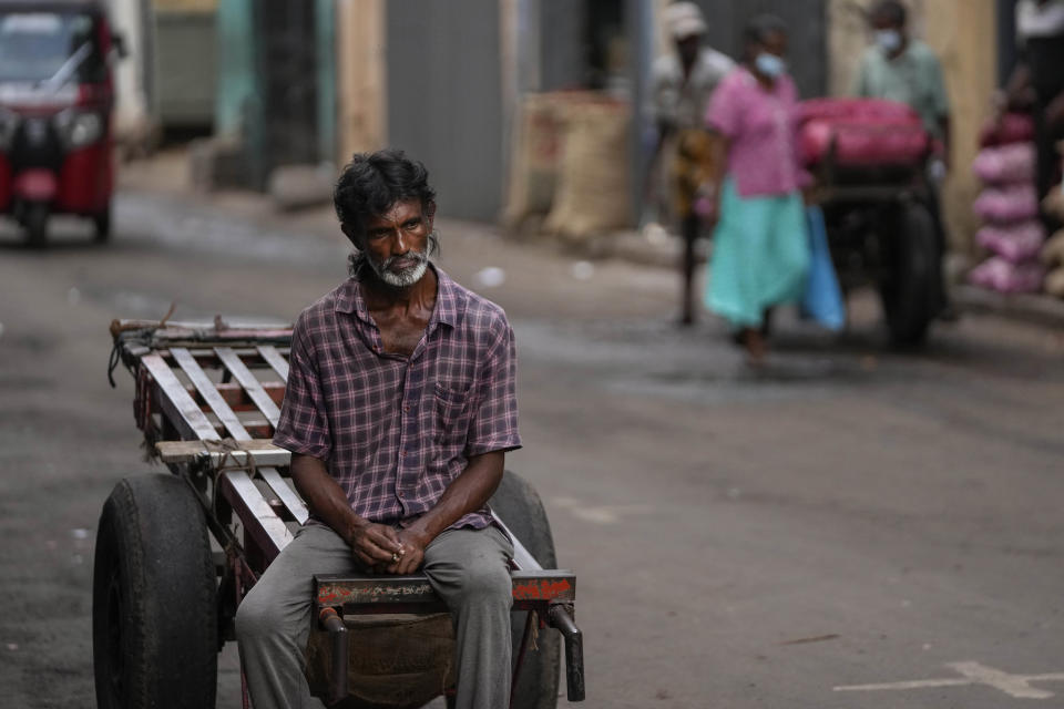 FILE - A daily wage laborer waits for work at a wholesale market in Colombo, Sri Lanka, Sunday, June 26, 2022. Sri Lankans have endured months of shortages of food, fuel and other necessities due to the country's dwindling foreign exchange reserves and mounting debt, worsened by the pandemic and other longer term troubles. Some 1.6 billion people in 94 countries face at least one dimension of the crisis in food, energy and financial systems, according to a report last month by the Global Crisis Response Group of the United Nations Secretary-General. (AP Photo/Eranga Jayawardena, File)