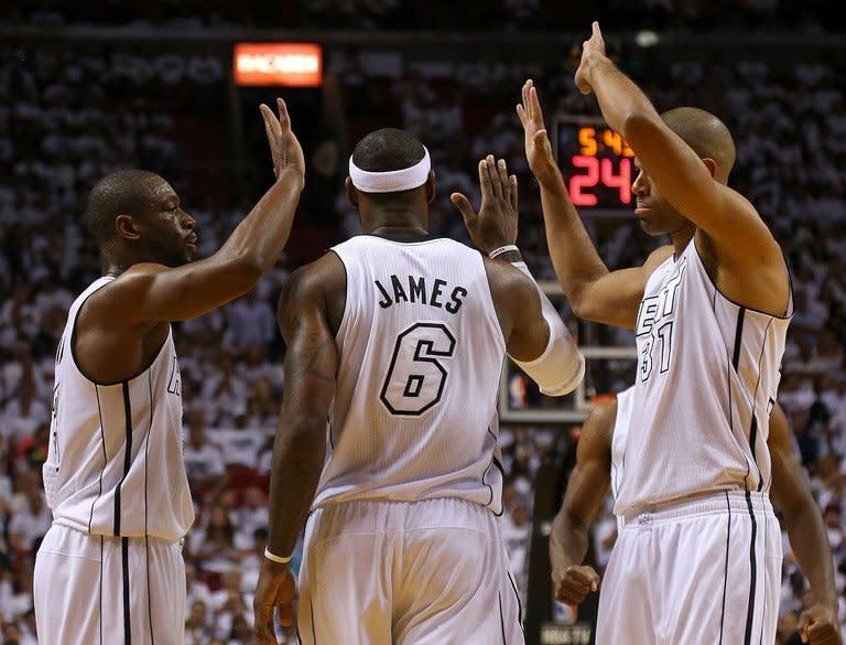 LeBron James is congratulated by Dwyane Wade (L) and Shane Battier on April 21, 2013. James fell two assists shy of a triple-double, scoring 27 points and grabbing 10 rebounds with eight assists as the Miami Heat drew first blood in the best-of-seven Eastern Conference first-round series
