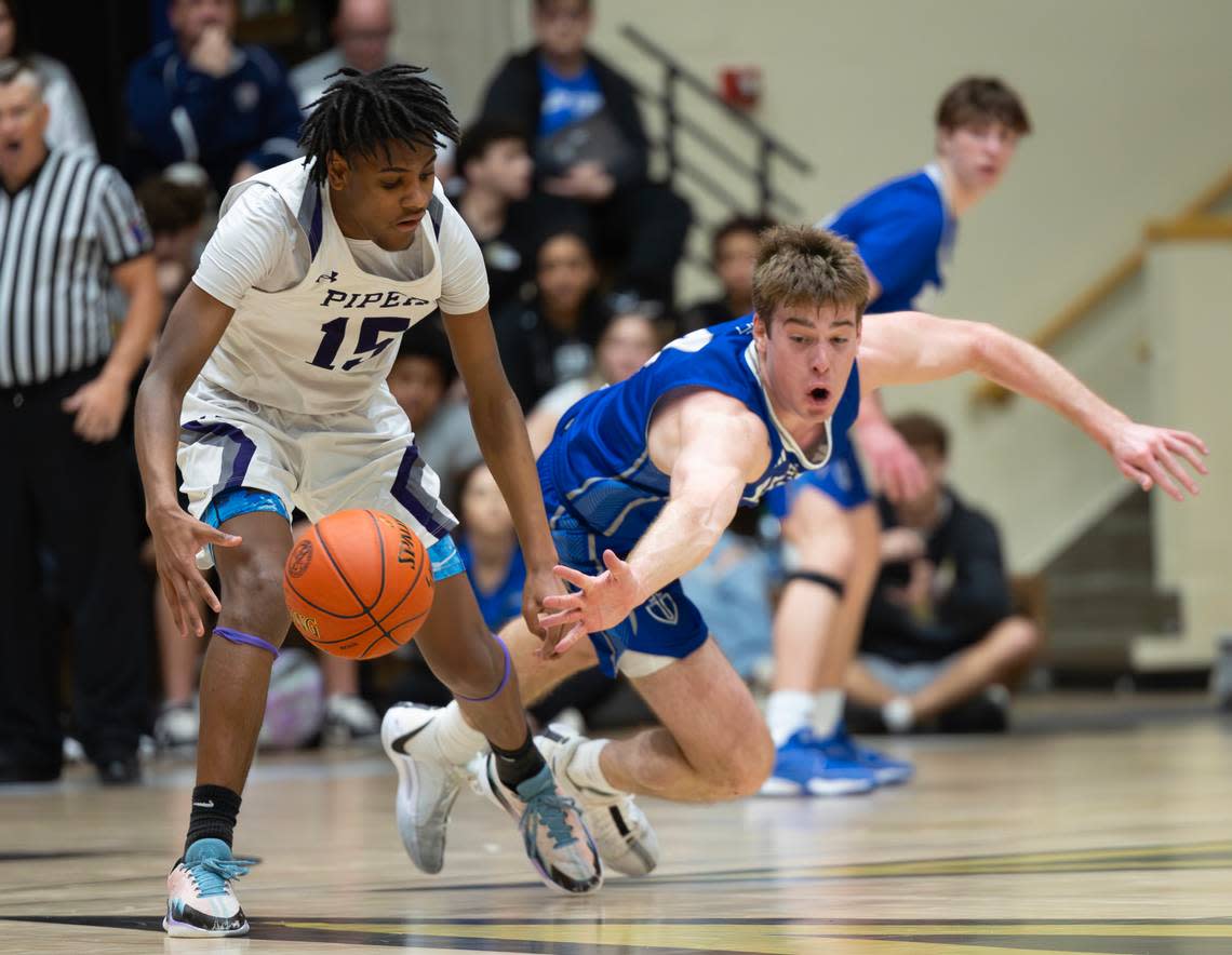 Kapaun’s William Thengvall tries to force a turnover against Kansas City Piper’s Derrick Jackson during the 5A state title game on Saturday in Emporia.