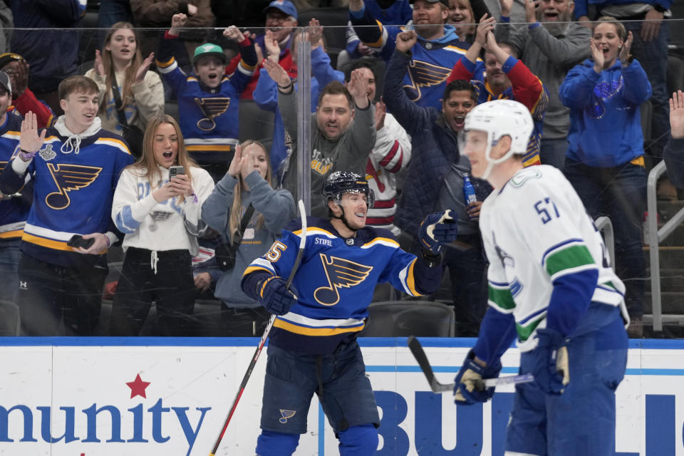 St. Louis Blues' Jakub Vrana (15) celebrates after scoring the game-winning goal in overtime of an NHL hockey game as Vancouver Canucks' Tyler Myers (57) skates past Tuesday, March 28, 2023, in St. Louis. (AP Photo/Jeff Roberson)