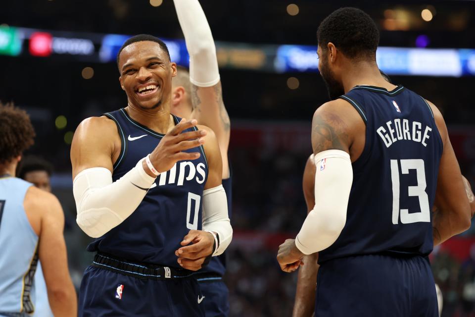 Los Angeles guard Russell Westbrook (0) smiles after forward Paul George (13) makes a three point basket against the Memphis Grizzlies at Crypto.com Arena.