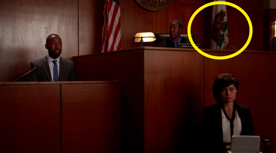 The California state flag, which has a bear on it, is in a court room