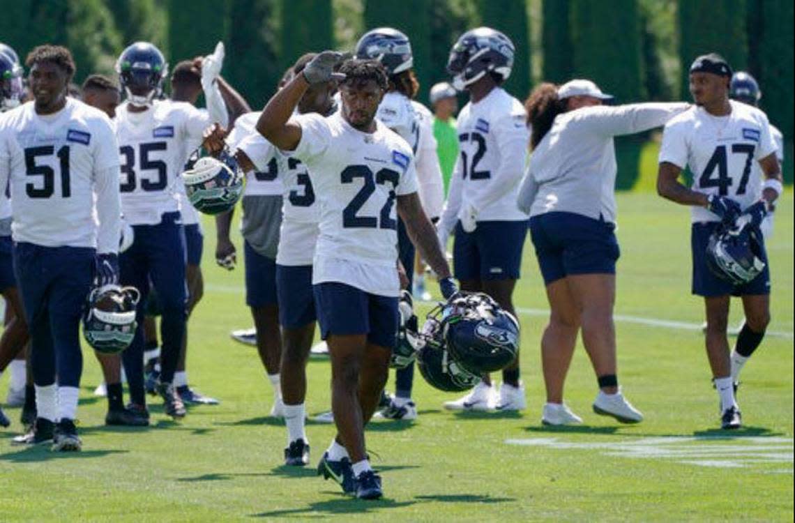 Cornerback Tre Brown (22) gets the rookie treatment carrying veterans’ helmets off the field following practice at Seahawks training camp in Renton.