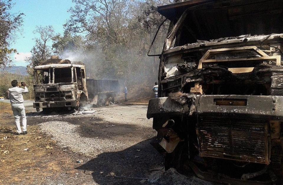 An Indian man takes photographs of charred vehicles after an ambush by Maoist rebels in Sukma district in the eastern Indian state of Chhattisgarh, Tuesday, March 11, 2014. Indian Maoist rebels ambushed paramilitary soldiers in a brazen daytime attack Tuesday, killing 20 at a camp in a remote central forest and putting authorities on alert just weeks before national elections. (AP Photo)