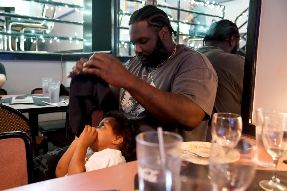 Cincinnati Bengals defensive tackle DJ Reader plays with his son, Rocky, at a dinner he hosted for the coaches of his football camp, Friday, June 16, 2023, in Greensboro, N.C.