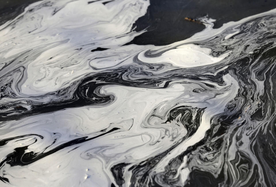 FILE - Coal ash swirls on the surface of the Dan River following one of the worst coal-ash spills in U.S. history into the river in Danville, Va., Feb. 5, 2014. The Environmental Protection Agency is moving to strengthen a rule aimed at controlling and cleaning up toxic waste from coal-fired power plants. A proposed rule announced Wednesday, May 17, 2023, would require safe management of so-called coal ash dumped in areas that currently are unregulated at the federal level. (AP Photo/Gerry Broome, File)