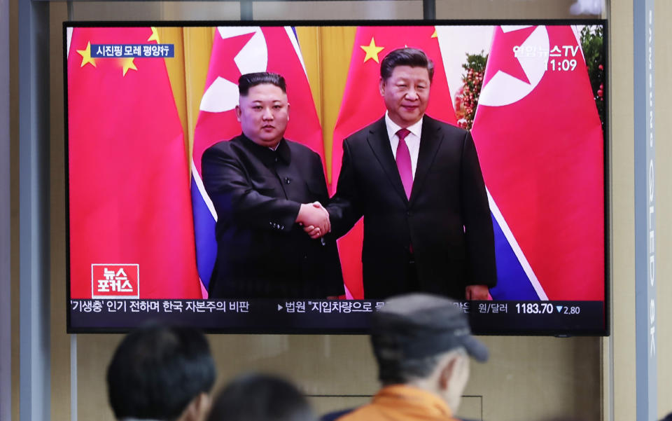 People watch a TV news program reporting about Chinese President Xi Jinping's state visit to North Korea with file footage of Xi and North Korean leader Kim Jong Un at the Seoul Railway Station in Seoul, South Korea, Tuesday, June 18, 2019. (AP Photo/Lee Jin-man)