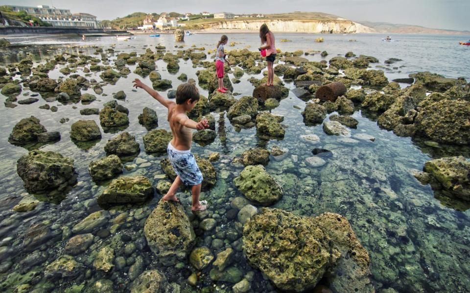 kids walking on rocks in sea - VISIT ISLE OF WIGHT