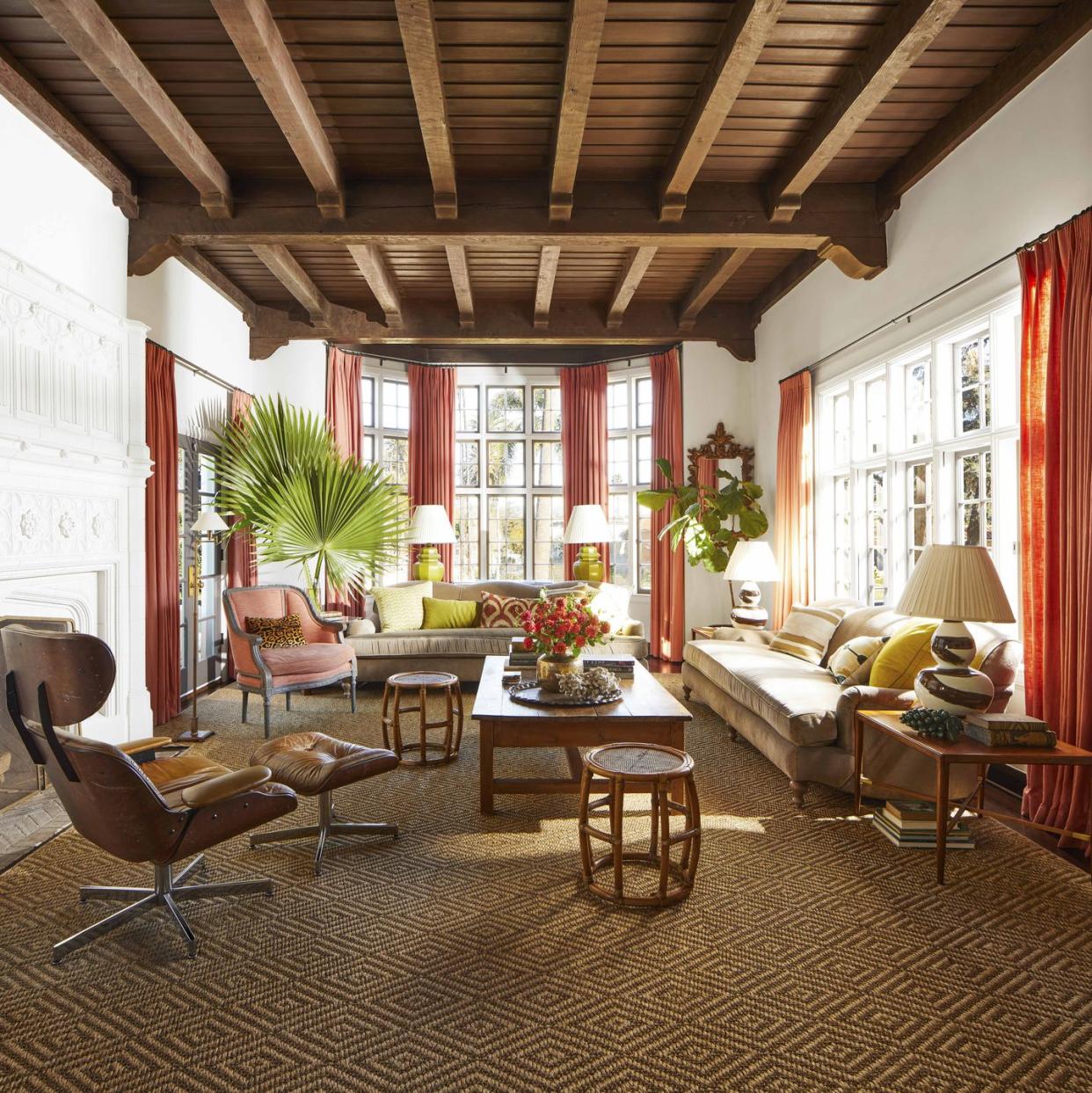 in the light filled family room a pair of english roll arm sofas and a french style armchair and an eames lounger