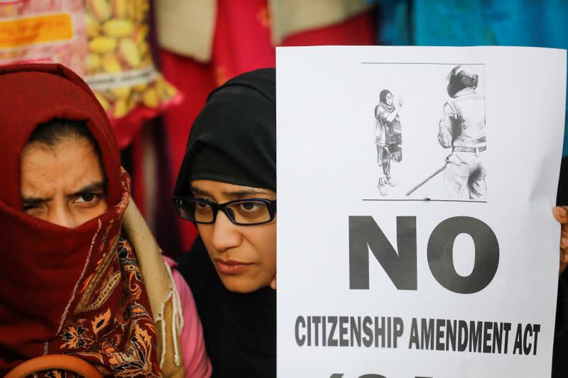 A demonstrator holds a poster during a protest against a new citizenship law, outside the Jamia Millia Islamia University in New Delhi